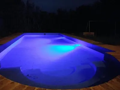a swimming pool lit up blue at night at Al lado in Cordoba