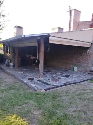 a brick house with a porch with a table at Al lado in Cordoba