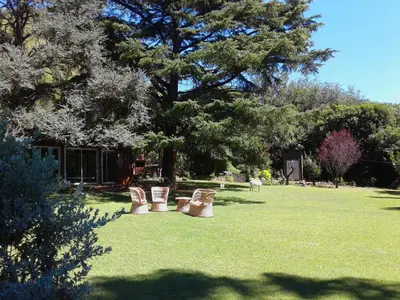 a group of chairs sitting in the grass in a park at Casita de Piedra B&B in Villa del Dique