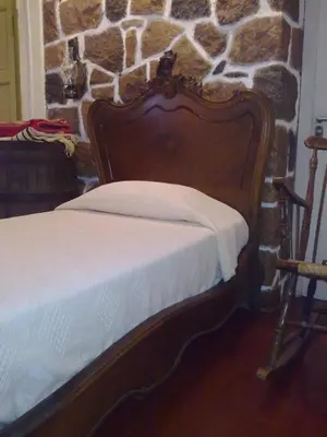 a bed in a room with a stone wall at Casita de Piedra B&B in Villa del Dique