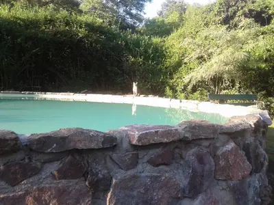 a stone retaining wall next to a swimming pool at Casita de Piedra B&B in Villa del Dique