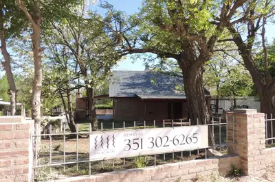 a house with a sign in front of a fence at Las Acacias in Nono