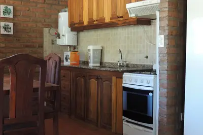 a kitchen with a sink and a stove top oven at Las Acacias in Nono