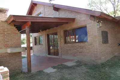 a brick house with a wooden pergola on it at Las Acacias in Nono