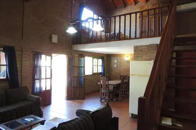 a living room with a staircase and a dining room at Las Acacias in Nono