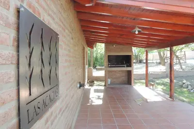 a patio with a brick wall with a fireplace at Las Acacias in Nono