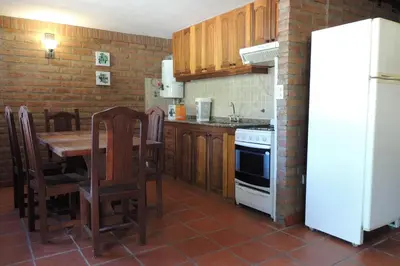 a kitchen with a table and a white refrigerator at Las Acacias in Nono