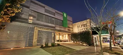 a building with a green sign on the side of it at Hotel Alpre in Villa Carlos Paz