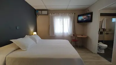 a hotel room with a bed and a television at Hotel Alpre in Villa Carlos Paz
