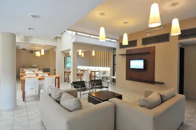 a living room with two couches and a dining room at Hotel Alpre in Villa Carlos Paz