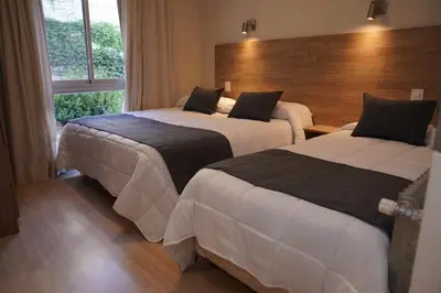 a hotel room with two beds and a window at Hotel Alpre in Villa Carlos Paz