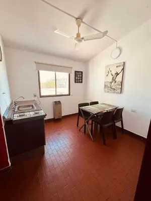 a kitchen and dining room with a table and a ceiling fan at Departamentos Centricos Carlos Paz in Villa Carlos Paz