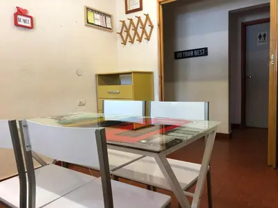 a glass table and a white chair in a room at Departamentos Centricos Carlos Paz in Villa Carlos Paz