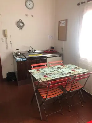 a kitchen with a table with two chairs and a sink at Departamentos Centricos Carlos Paz in Villa Carlos Paz