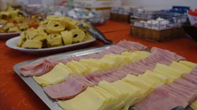 a table with different types of cheese and other foods at Hotel Marqués del Lago in Villa Carlos Paz