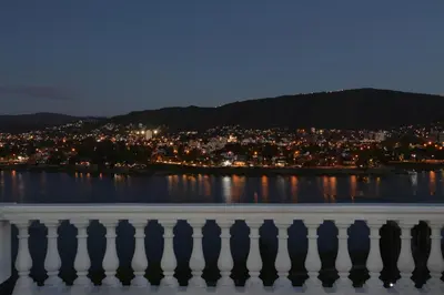 a view of a city from the water at night at Hotel Marqués del Lago in Villa Carlos Paz