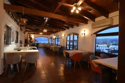 a dining room with tables and chairs in a restaurant at Hotel Marqués del Lago in Villa Carlos Paz