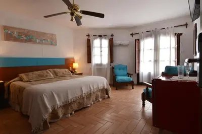 a bedroom with a bed and a ceiling fan at Hotel Marqués del Lago in Villa Carlos Paz