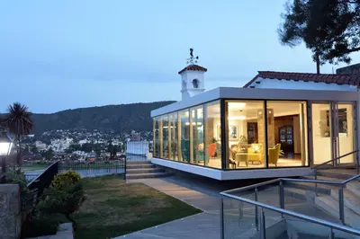 a glass house with a lighthouse on top of it at Hotel Marqués del Lago in Villa Carlos Paz