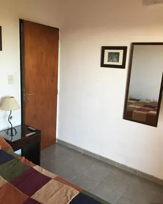 a bedroom with a bed and a mirror on the wall at Paz y Armonia Habitaciones in Mina Clavero