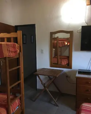 a room with a mirror and a table and bunk beds at Paz y Armonia Habitaciones in Mina Clavero