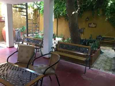 three benches and a tree in a courtyard at Paz y Armonia Habitaciones in Mina Clavero