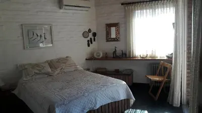 a bedroom with a bed and a window at Homero y Martín Coronado in Villa Carlos Paz