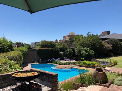a garden with a fire pit and a swimming pool at Homero y Martín Coronado in Villa Carlos Paz