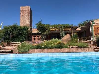 a swimming pool in front of a house at Homero y Martín Coronado in Villa Carlos Paz
