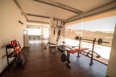 a gym with several tread machines and a large window at Hotel Estilo MB - Villa Carlos Paz in Villa Carlos Paz