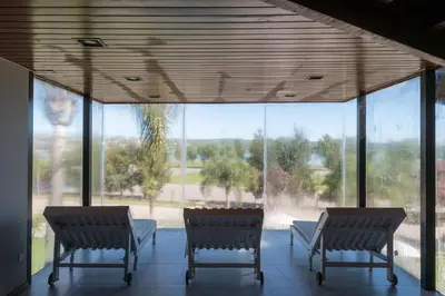 two chairs sitting in a room with a large window at Portal del Lago Hotel in Villa Carlos Paz