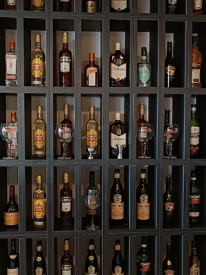a wall of bottles and glasses of alcohol at Portal del Lago Hotel in Villa Carlos Paz