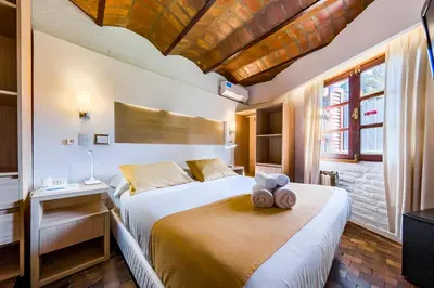 a bedroom with a bed with a teddy bear on it at Portal del Lago Hotel in Villa Carlos Paz