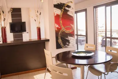 a dining room with a table and chairs and a painting at Kube Apartments Express in Cordoba