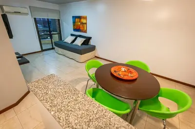 a dining room with a table and green chairs at Kube Apartments Express in Cordoba
