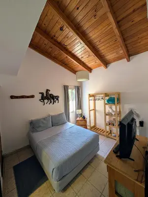 a bedroom with a bed and a tv in it at Preludio De Luxe in Villa General Belgrano
