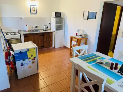 a kitchen with a white refrigerator and a table at Preludio De Luxe in Villa General Belgrano