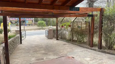 a wooden pavilion with a fence and a sidewalk at Preludio De Luxe in Villa General Belgrano