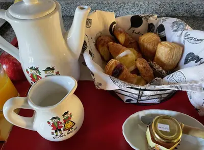 a table with a cup of coffee and a basket of pastries at Preludio De Luxe in Villa General Belgrano