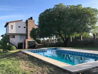 a swimming pool in front of a house at Hermosa casa con vista al lago in Villa Carlos Paz