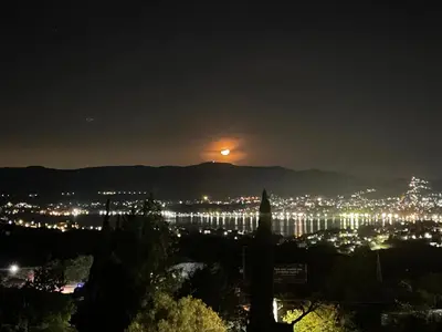 a view of a city at night with the moon at Hermosa casa con vista al lago in Villa Carlos Paz