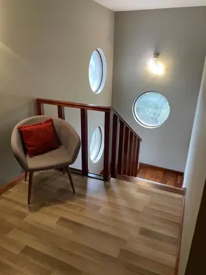 a living room with a chair and two windows at Hermosa casa con vista al lago in Villa Carlos Paz