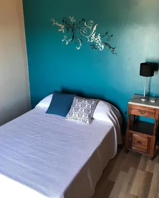 a bedroom with a bed and a blue wall at Hermosa casa con vista al lago in Villa Carlos Paz