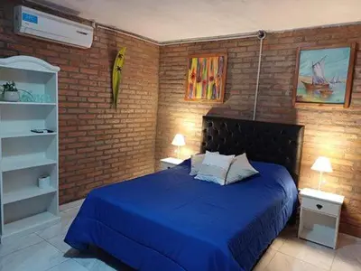 a bedroom with a blue bed and a brick wall at Costa Dorada in San Antonio de Arredondo