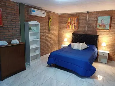 a bedroom with a blue bed and a brick wall at Costa Dorada in San Antonio de Arredondo