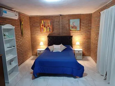 a bedroom with a blue bed with two night stands at Costa Dorada in San Antonio de Arredondo