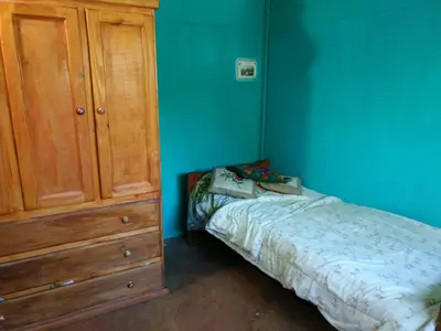 a bedroom with a bed and a wooden cabinet at Pintoresca Cabaña Céntrica a pasos del río Mina Clavero in Mina Clavero