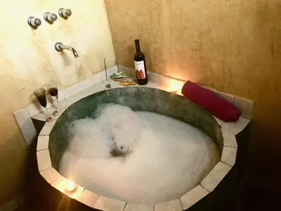 a bath tub filled with snow and a bottle of wine at Pintoresca Cabaña Céntrica a pasos del río Mina Clavero in Mina Clavero