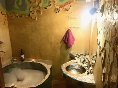 a bathroom with a bath tub and a sink at Pintoresca Cabaña Céntrica a pasos del río Mina Clavero in Mina Clavero