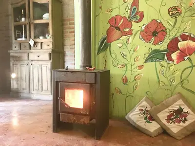 a fireplace in a room with a floral wall at Pintoresca Cabaña Céntrica a pasos del río Mina Clavero in Mina Clavero